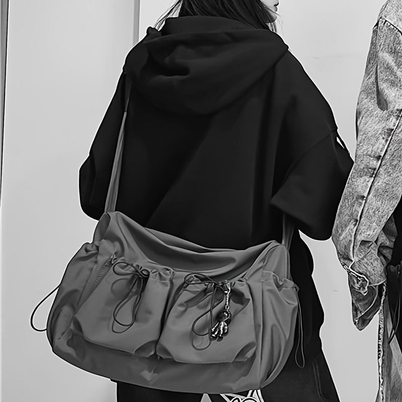 Women's crossbody bag showing drawstring top and pocket details