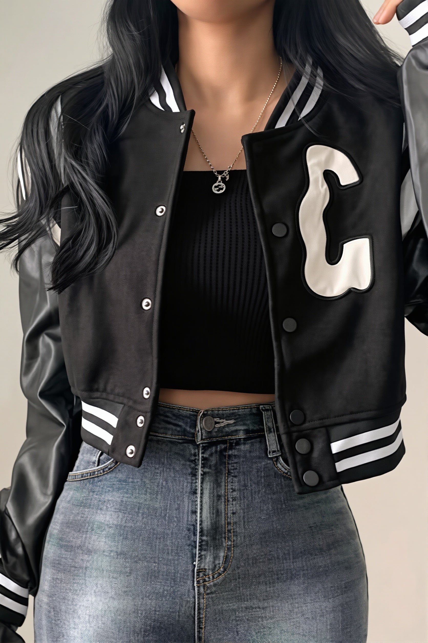 Close-up view of the letter patch on a cropped varsity jacket