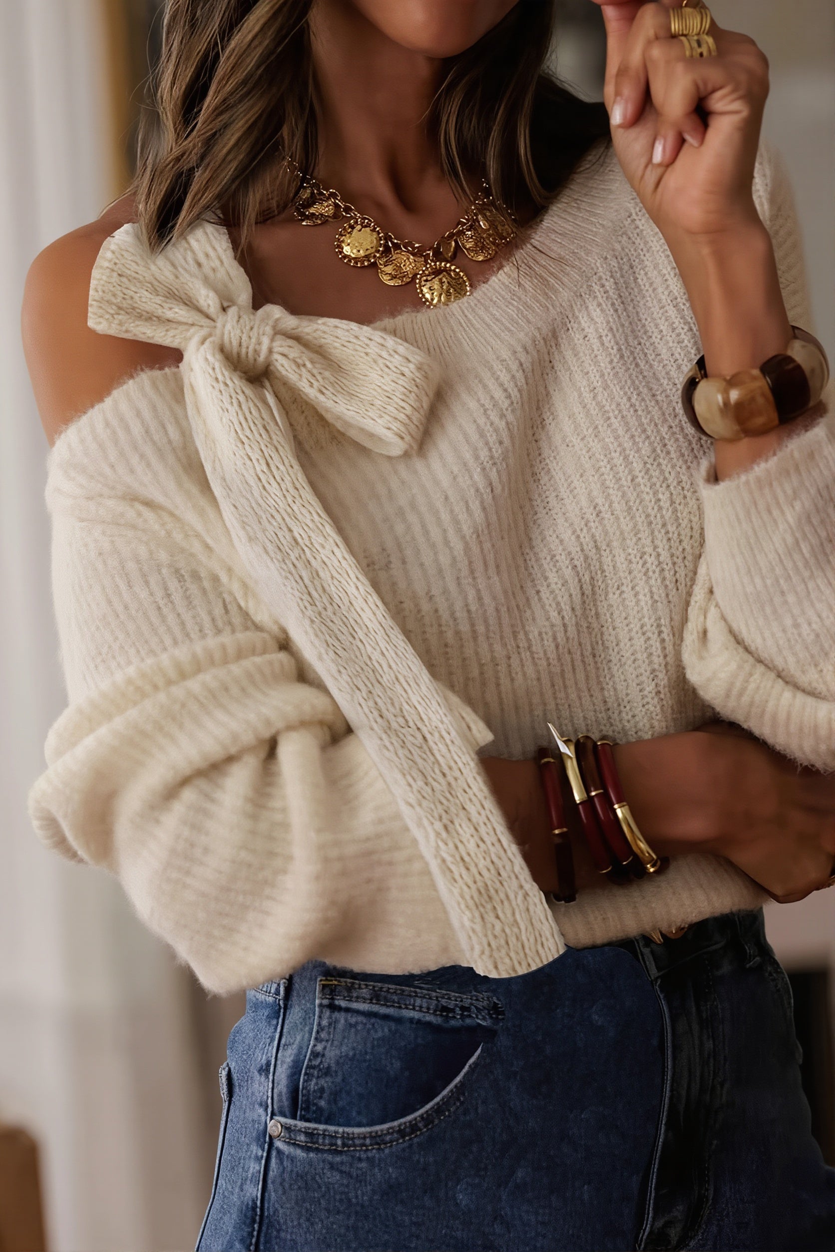 Women's oversized one-shoulder knit sweater with a bow applique detail