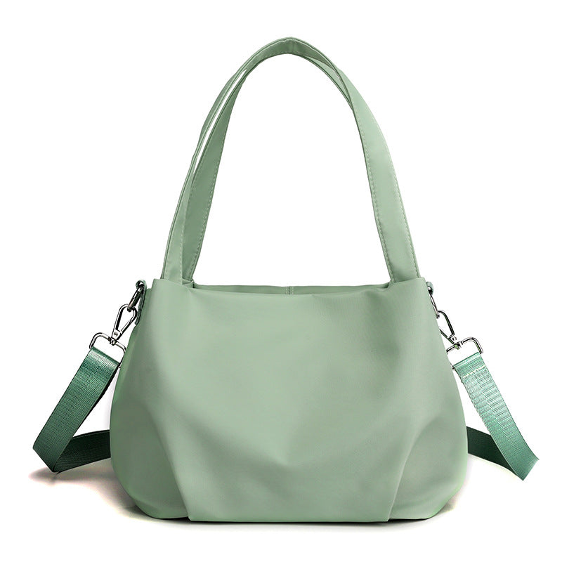 Women's waterproof shoulder bag with nylon exterior and compact everyday design