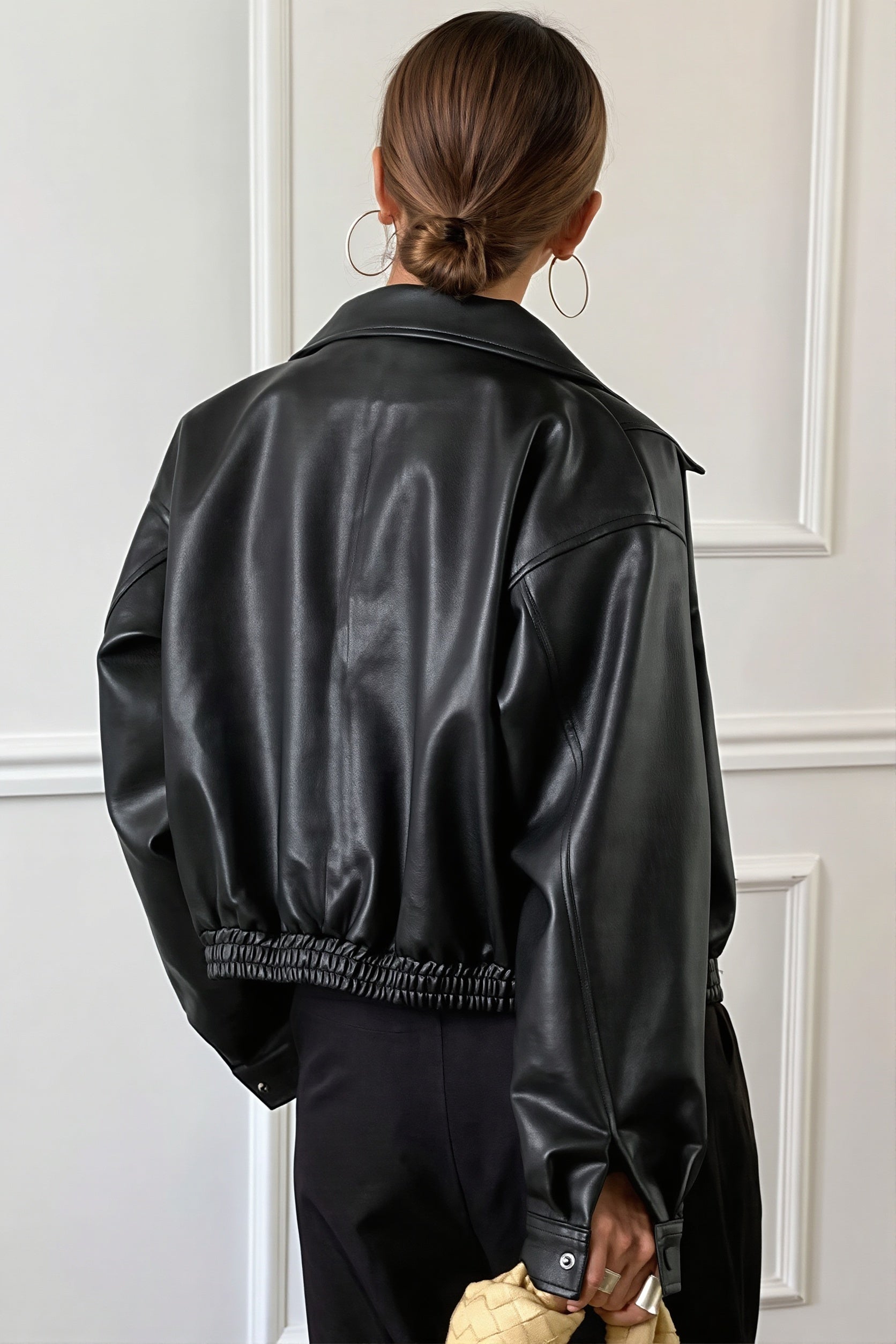 Close-up of the point collar and front closure on a faux leather jacket