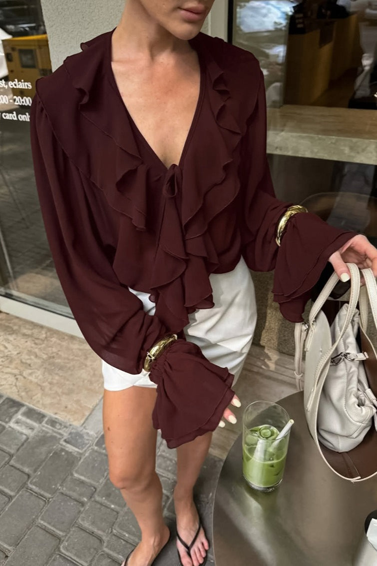 Close-up of the blouse's ruffle trim and tie neckline