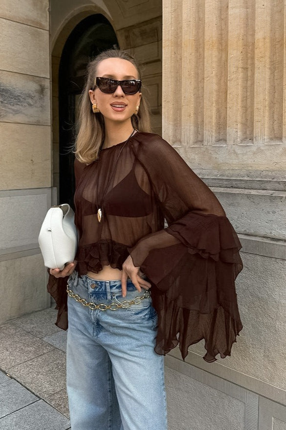 Close-up of the blouse's delicate chiffon fabric and ruffle sleeve