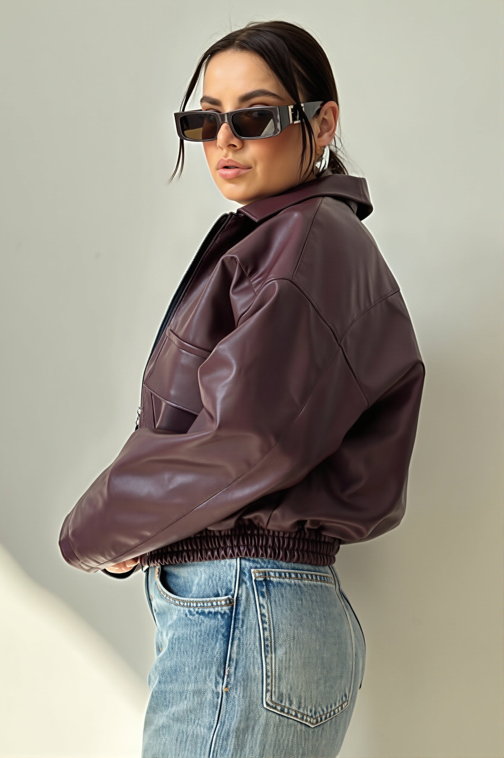Back view of a faux leather bomber jacket with a classic bomber fit