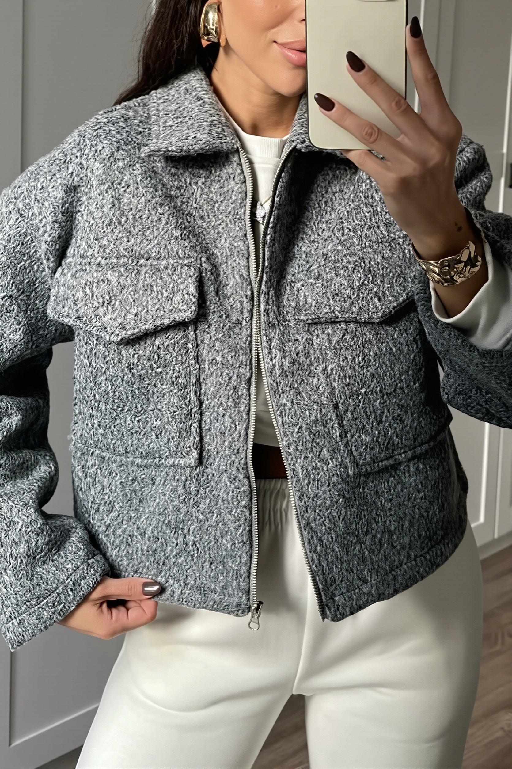 Close-up view of the bouclé texture and front zipper on the cropped jacket