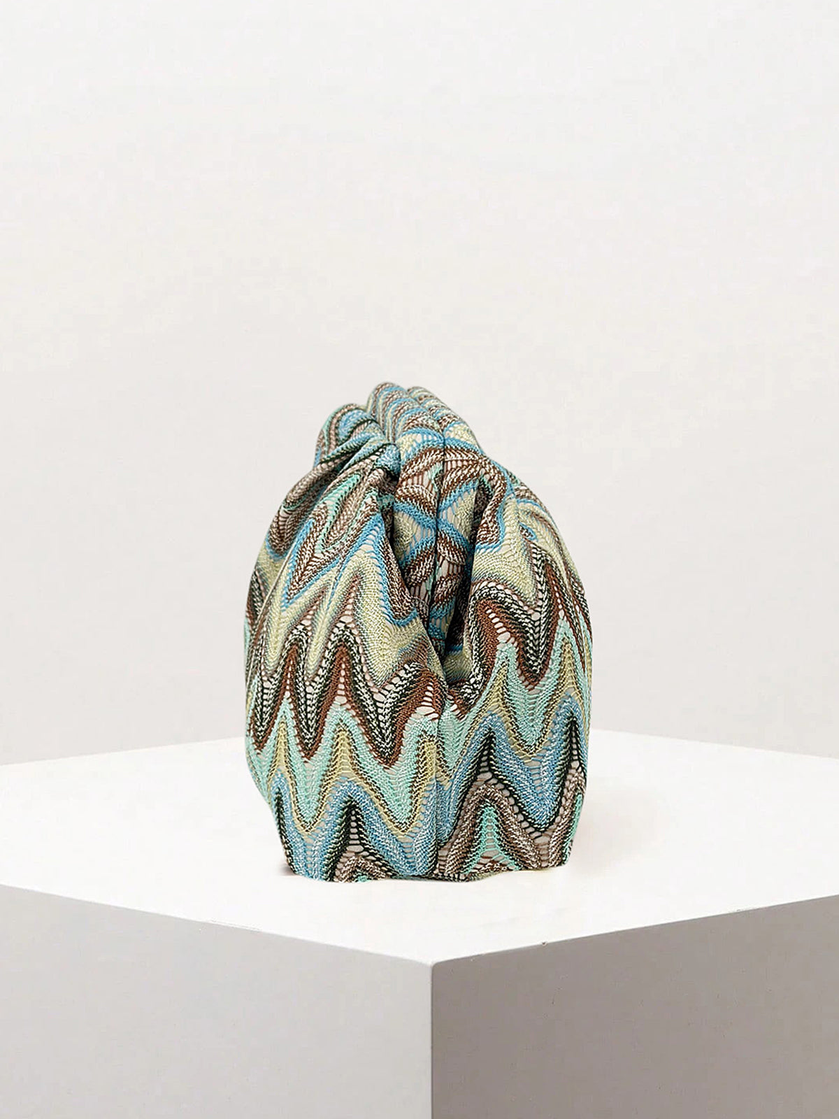 Ruched zigzag evening clutch bag angled to show texture and shape