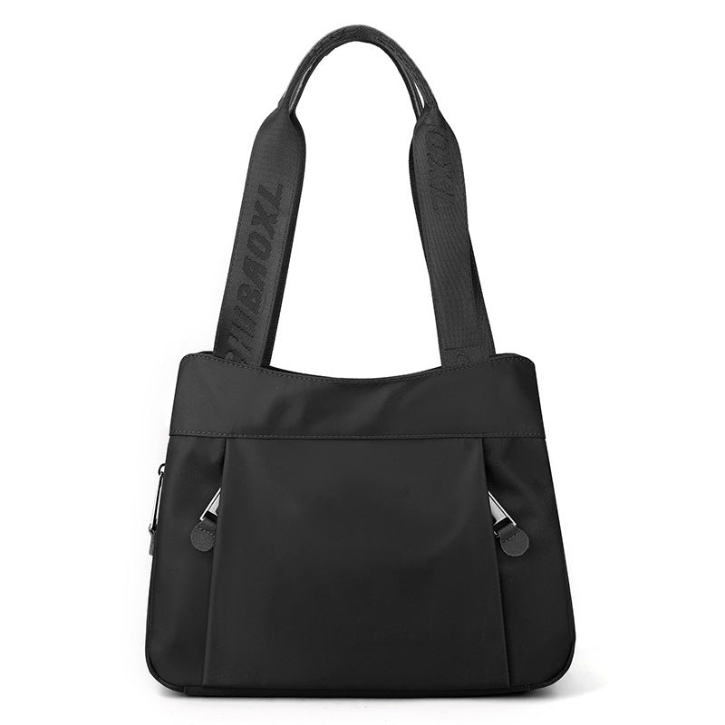 Black nylon crossbody bag with multiple zip compartments and adjustable shoulder strap