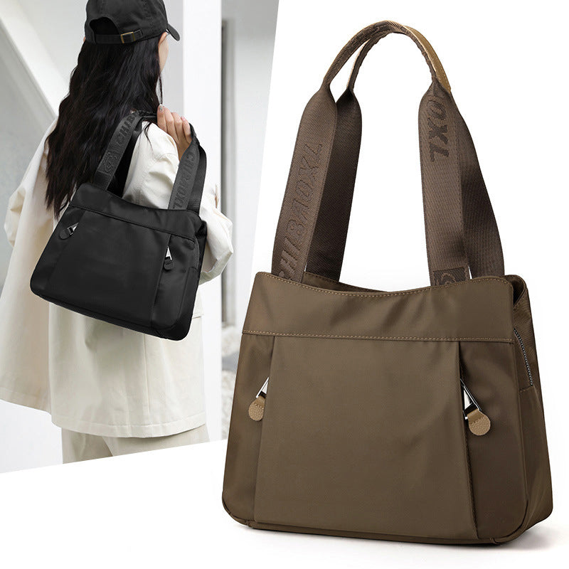 Front view of nylon crossbody bag showing multiple compartments and sleek everyday design
