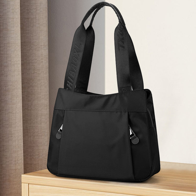 Side view of crossbody bag highlighting compact shape and layered storage compartments