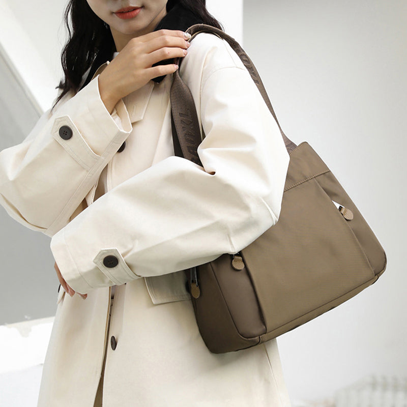 Close-up of zipper compartments and nylon fabric on the crossbody bag