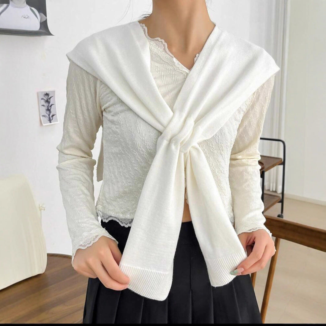 Women's knit scarf featuring a stylish knot detail, displayed flat.