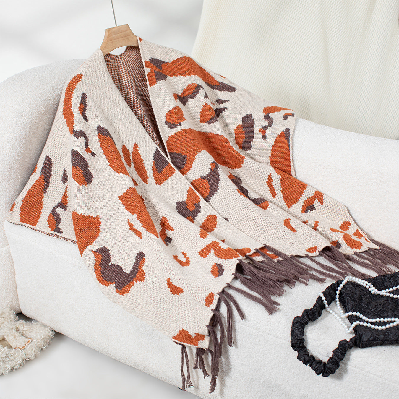Close-up of the scarf's soft fabric and fringed edge with leopard print detail.