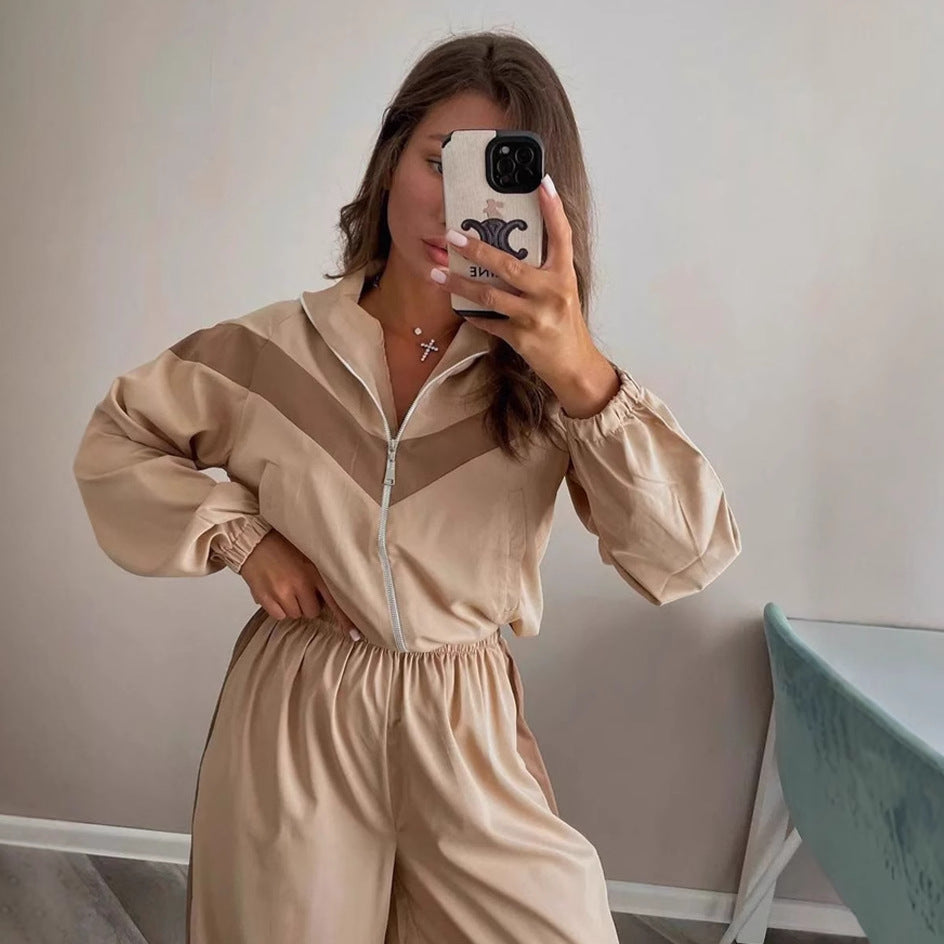 Front view of a women's satin track suit with a stand collar and chevron stripe