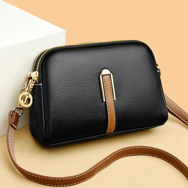 Women's faux leather handbag shown at an angle with top handles and shoulder strap