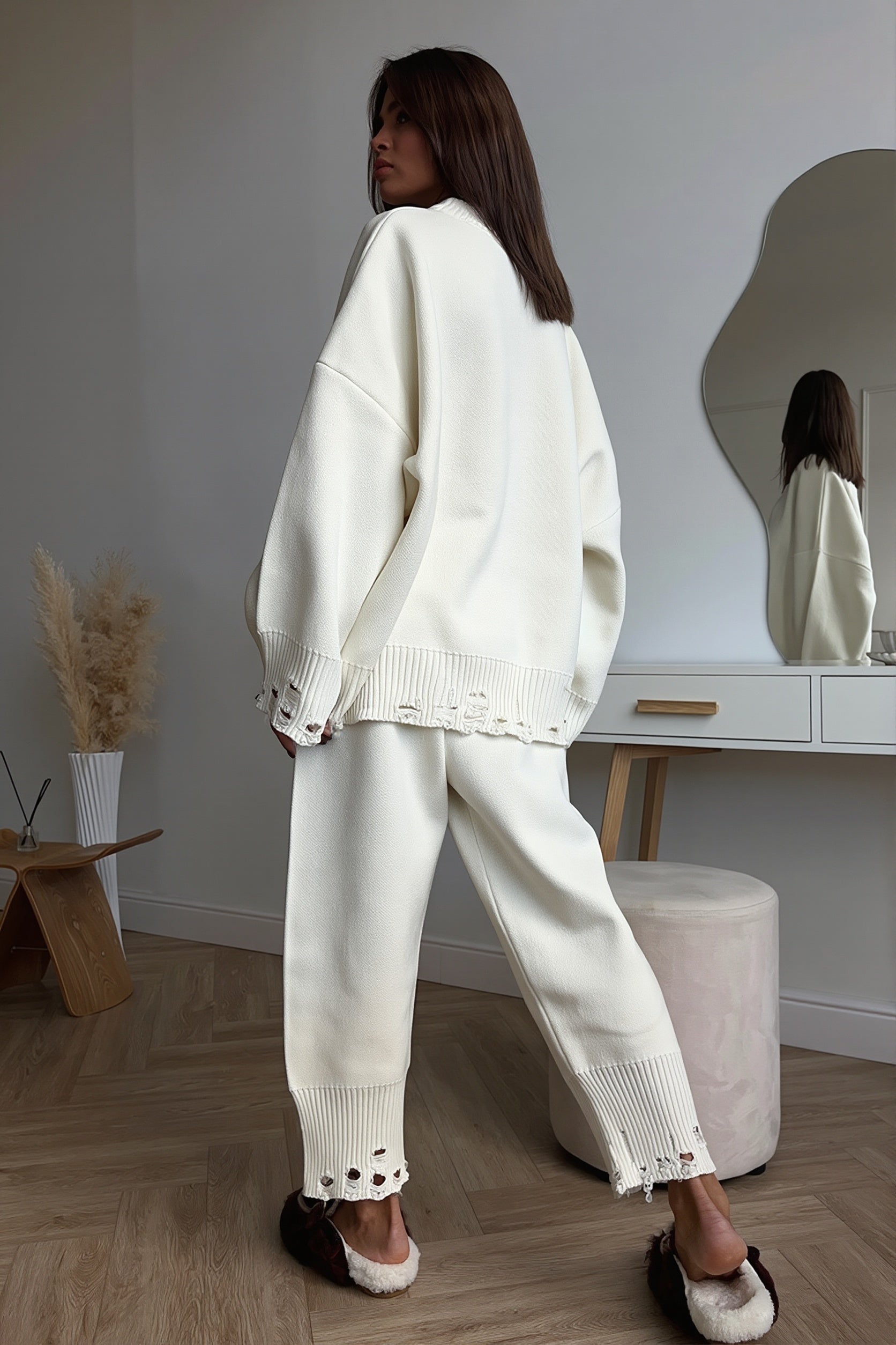 Front view of a distressed knit sweater and matching jogger pants set