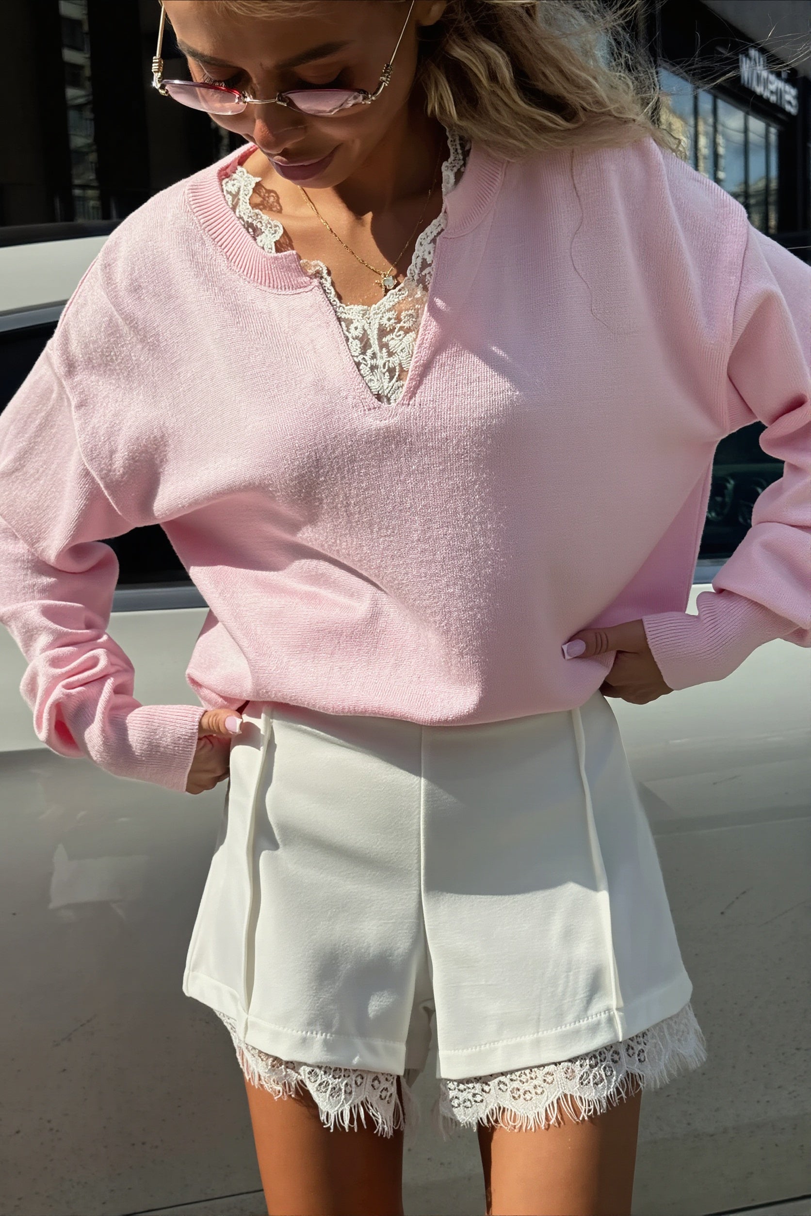 Front view of a relaxed sweater with a V-neckline and delicate lace trim