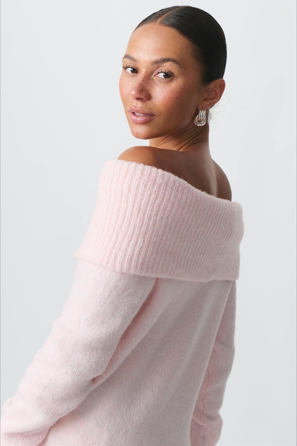 Back view of the fitted sweater with its relaxed off-shoulder neckline