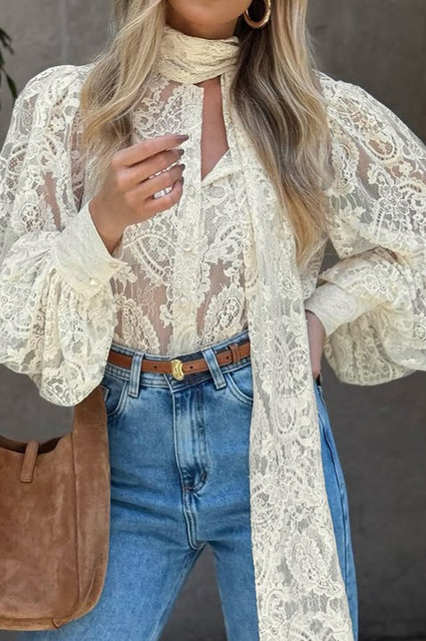 Close-up of the blouse's lace texture and scarf tie neckline