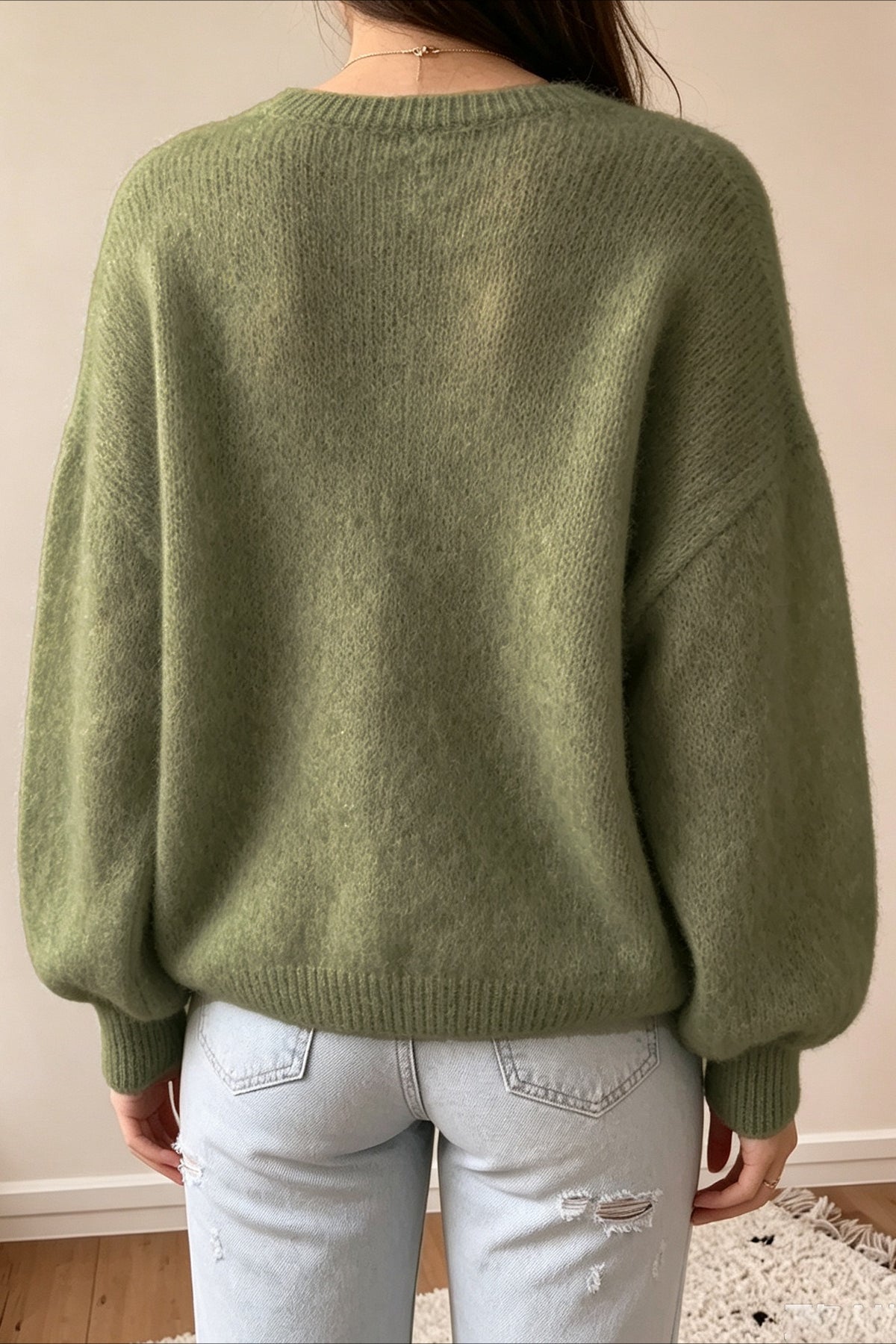 Close-up of the V-neckline and textured knit fabric on the sweater