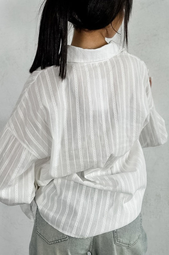 Side view of a lightweight sheer shirt with ruffle cuff sleeves