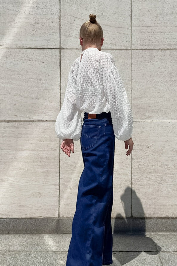 Side view of a white textured blouse with balloon sleeves
