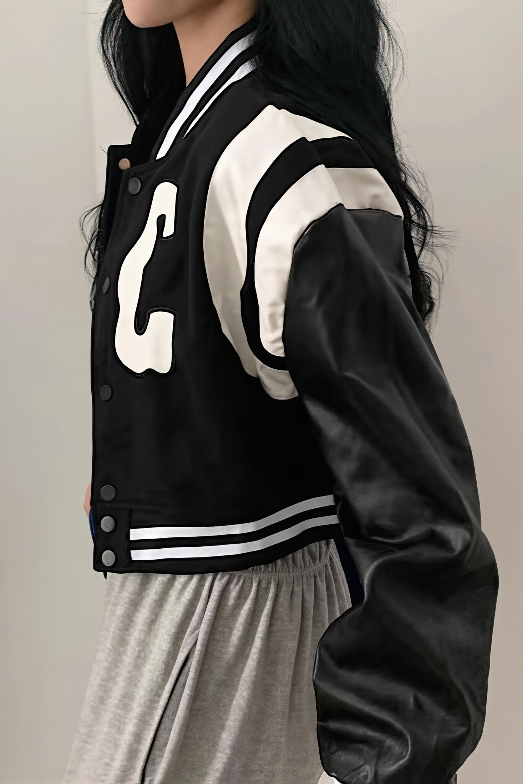 Cropped varsity jacket shown with ribbed trim and button front