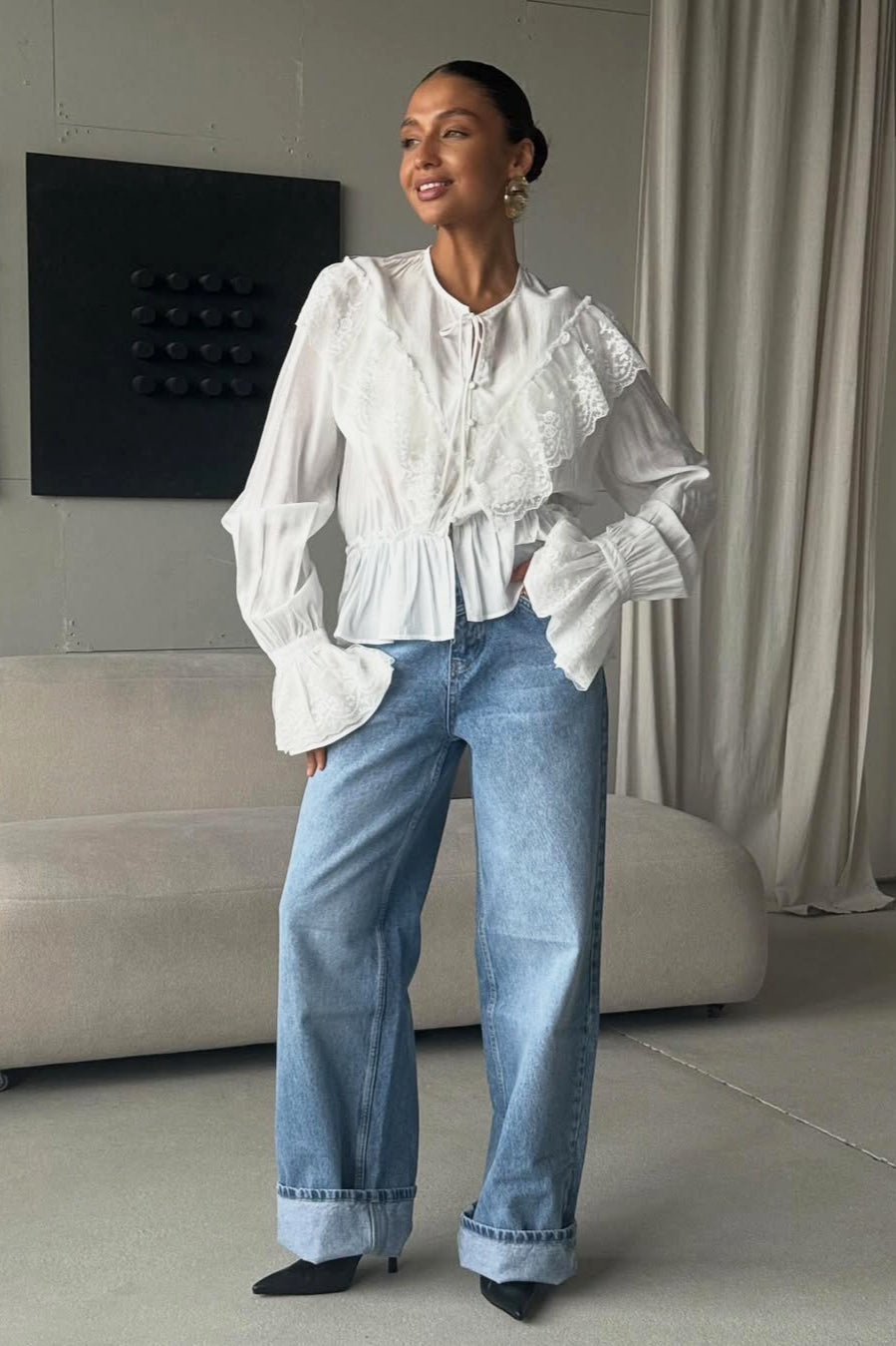 Front view of a women's lace yoke ruffle hem blouse