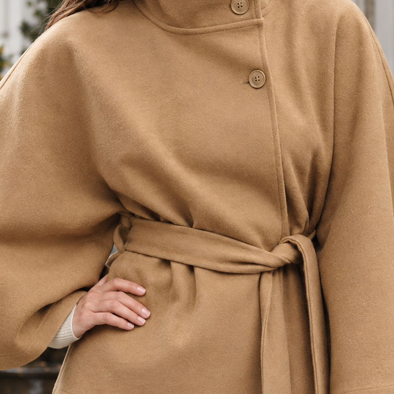Cape jacket displayed with its stand collar and tied waist belt