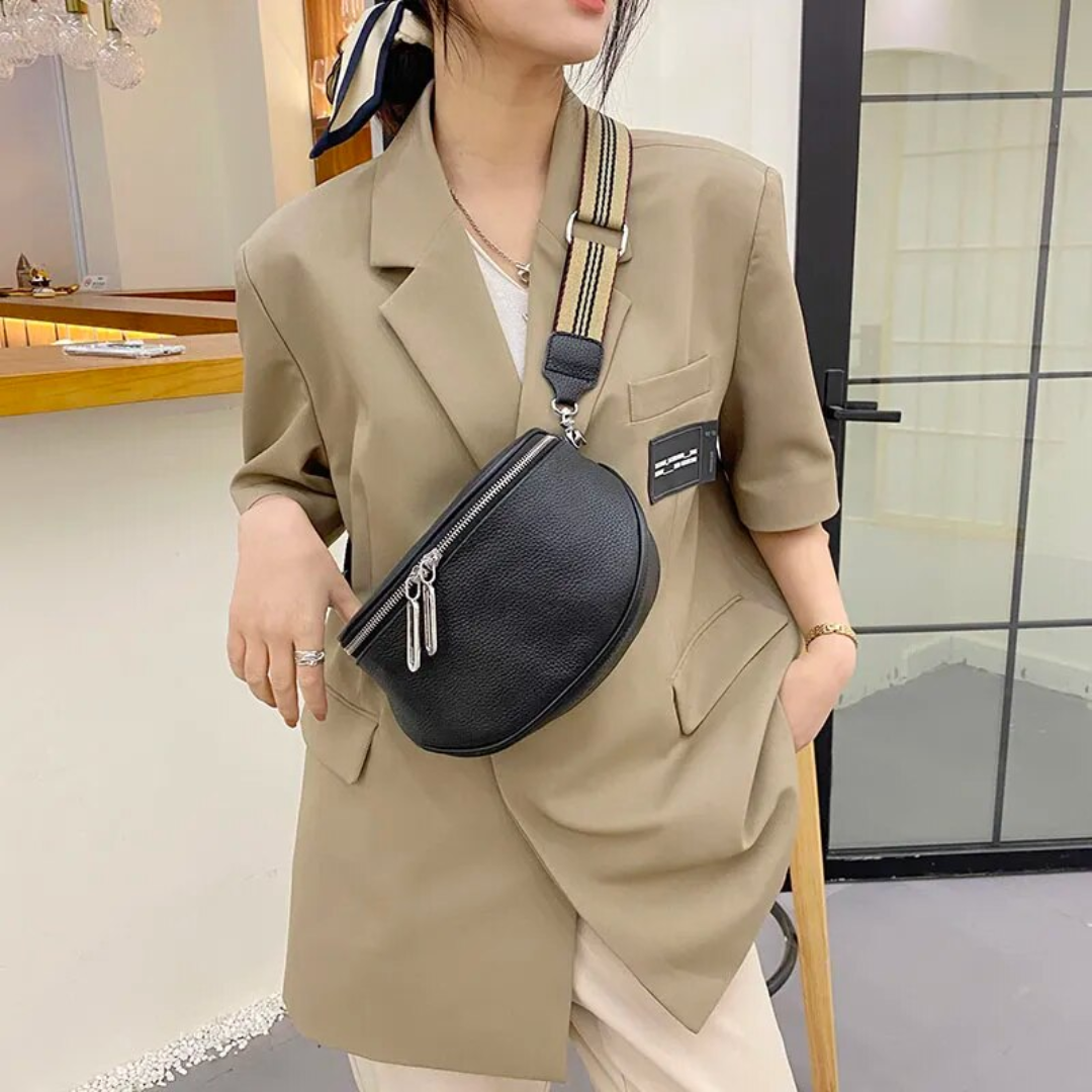 Compact leather saddle bag with strap detail and flap closure in close-up