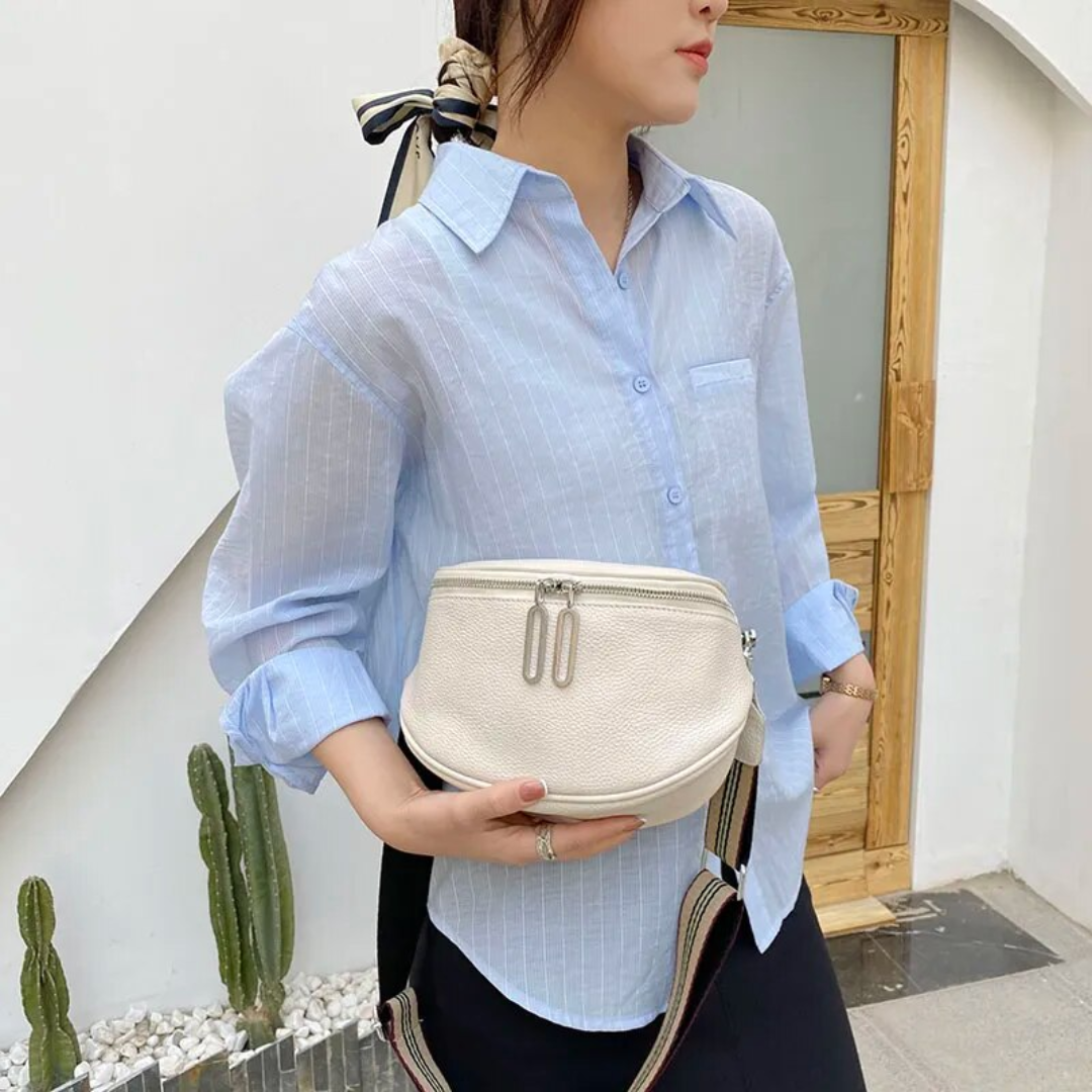 Compact leather saddle bag worn on the shoulder with casual outfit styling