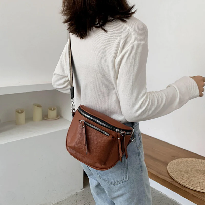 Leather crossbody bag with adjustable strap displayed on a white background