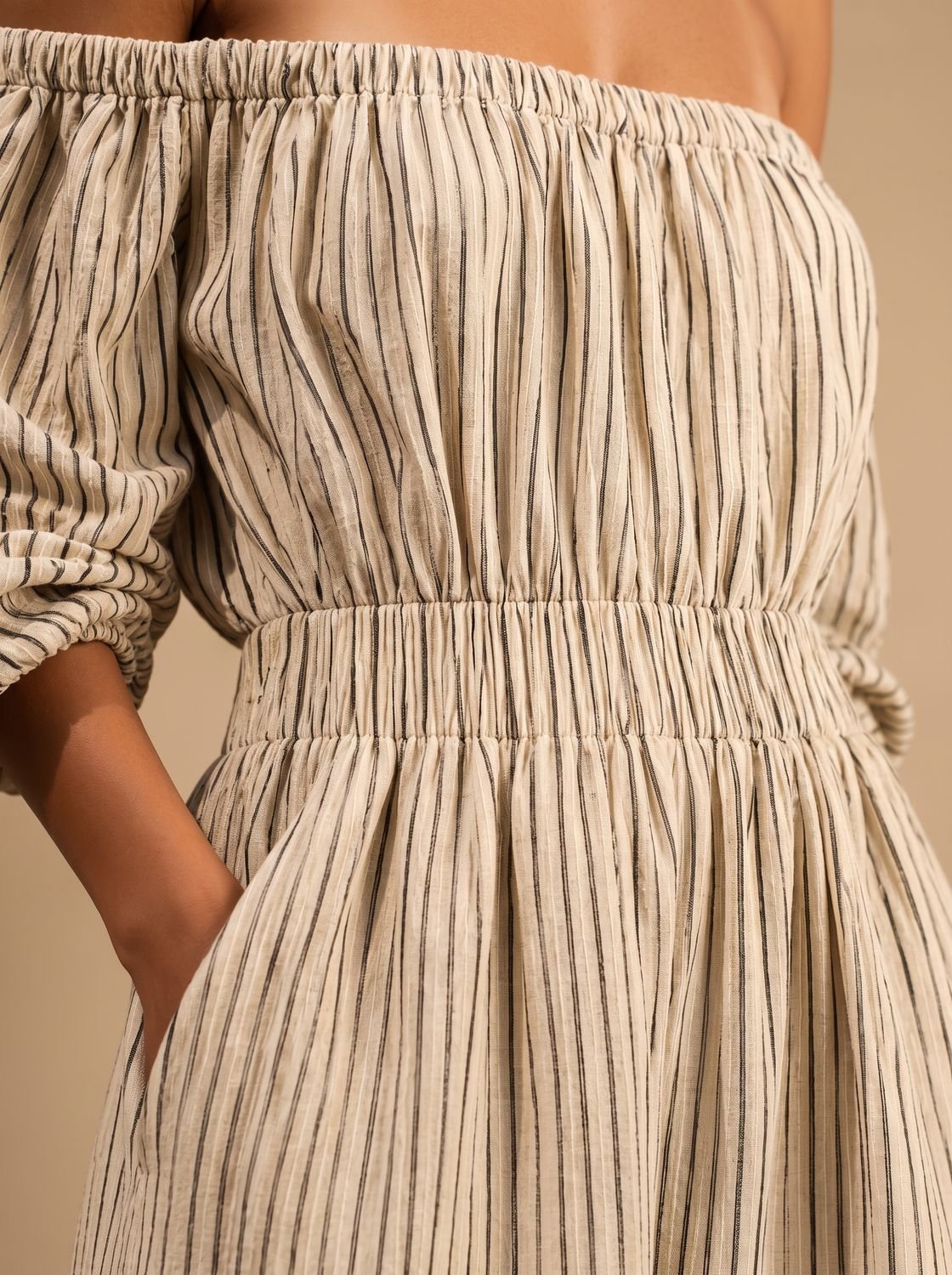 Off-shoulder neckline detail on a women's striped maxi dress