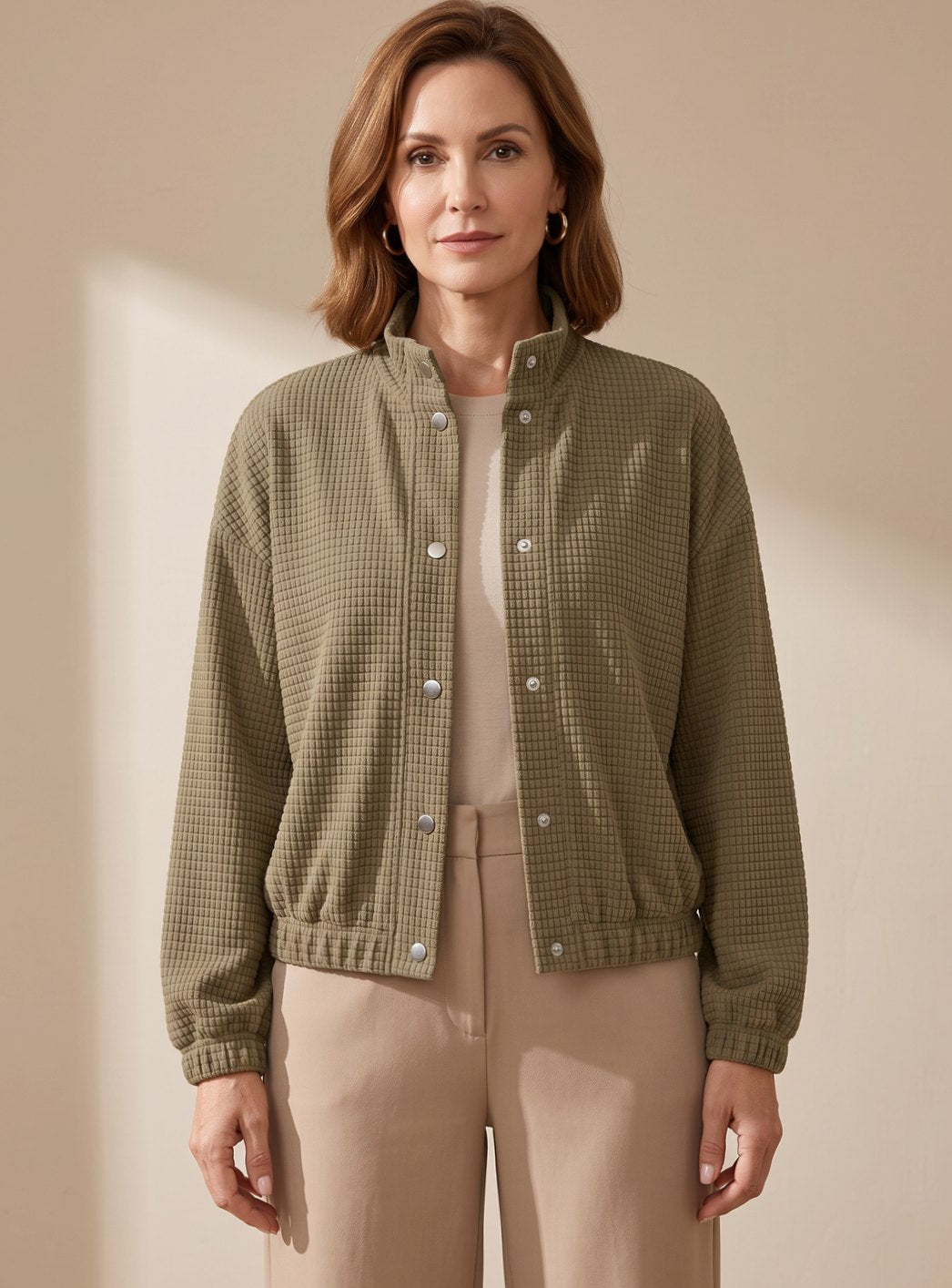 Front view of women's cropped waffle-knit jacket with a stand collar and button-up front
