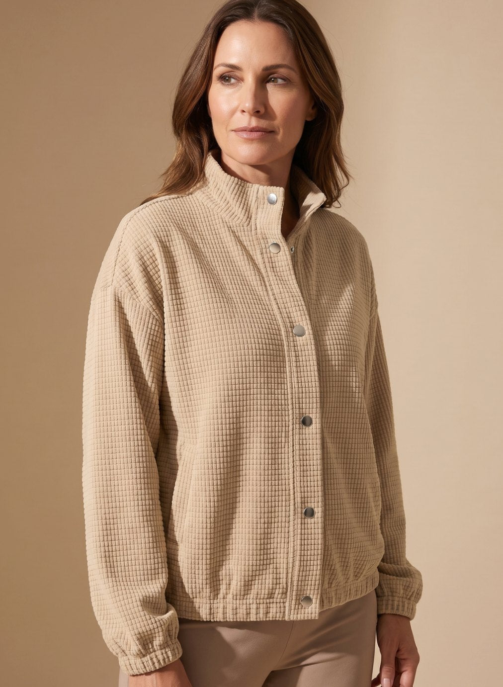 Women's cropped waffle-knit jacket shown from the back with a neat stand collar