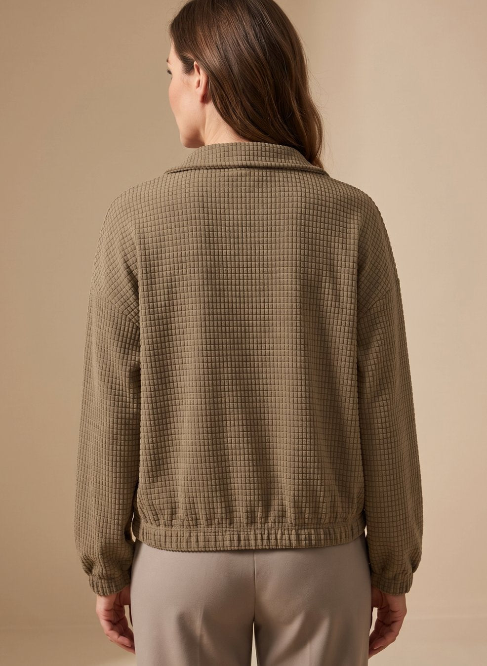 Detail view of the button-up front on a women's cropped waffle-knit jacket