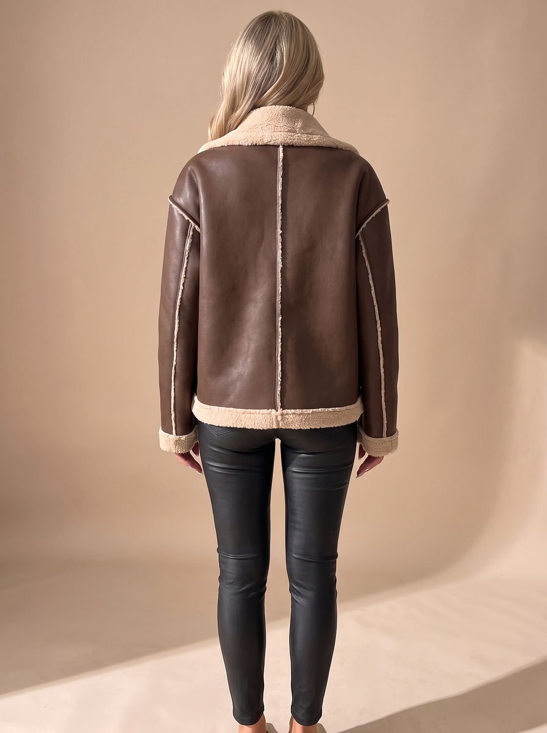 Front view of a women's faux leather sherpa-lined aviator jacket