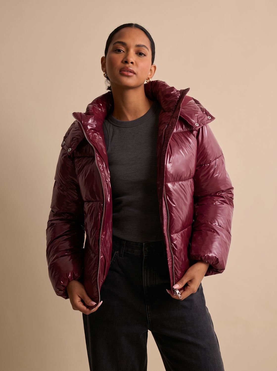 Women's glossy hooded quilted puffer jacket shown from the front