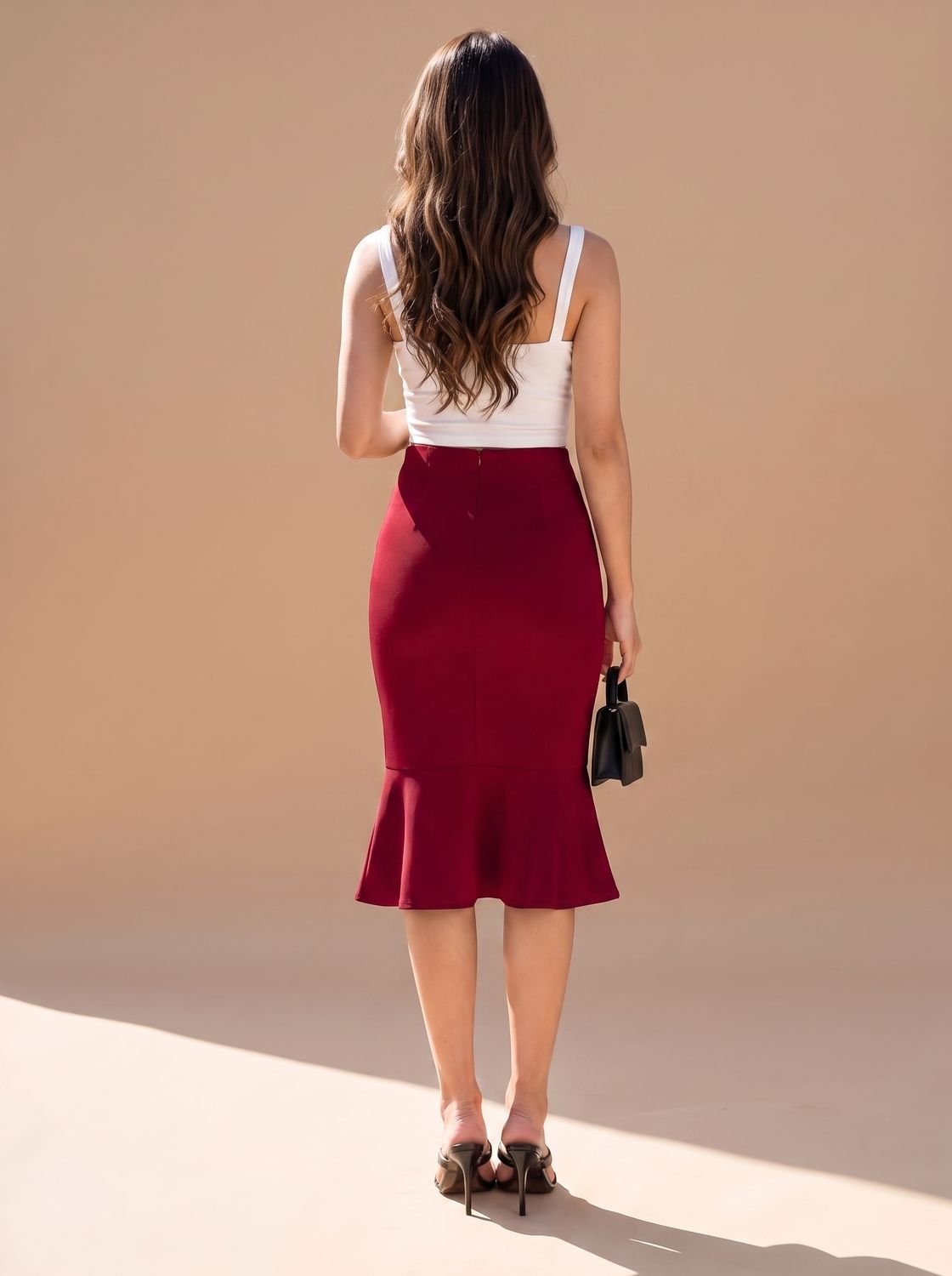 Back view showing the high waist and fishtail shape of the midi skirt