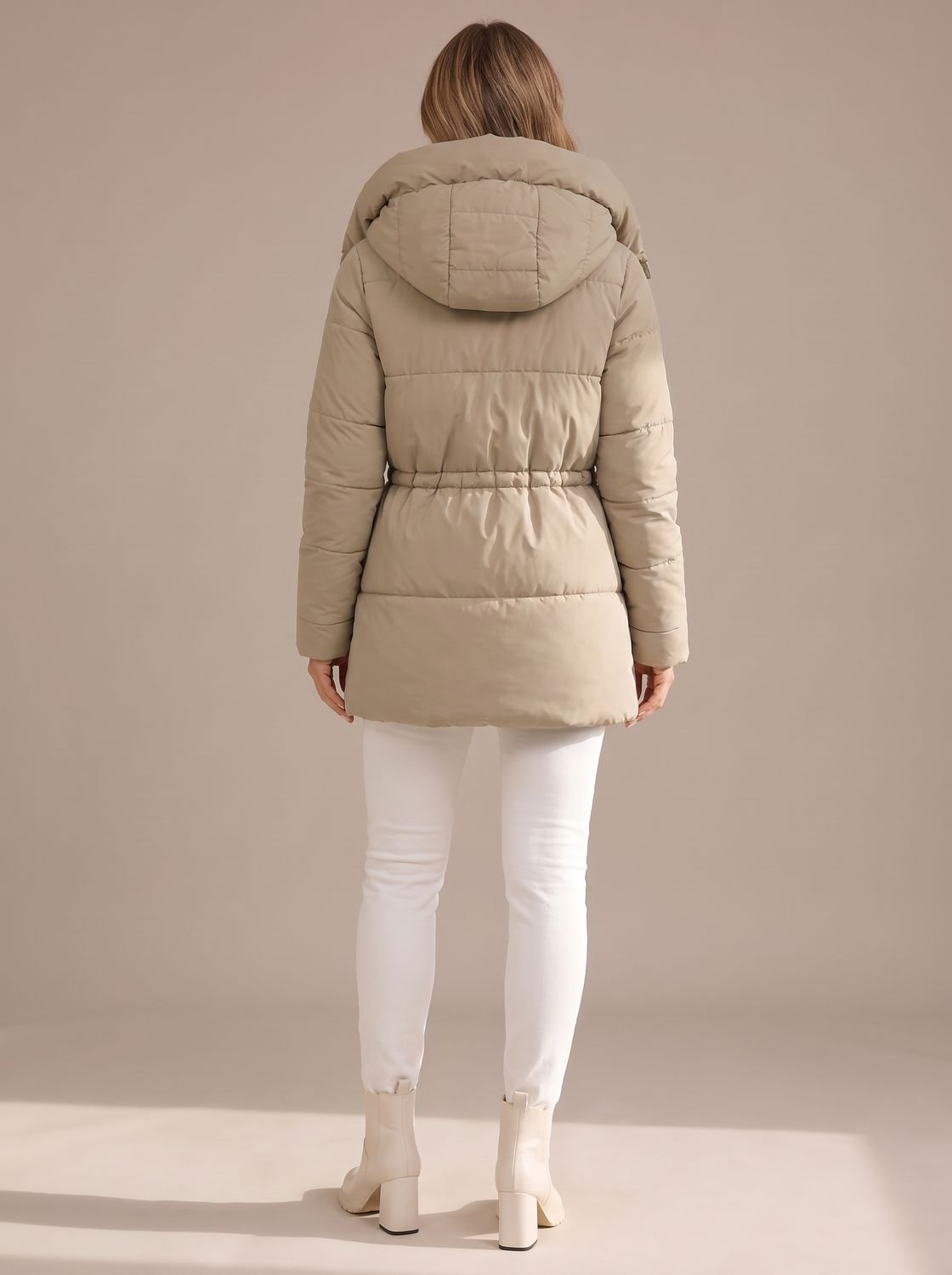 Women's puffer jacket showing the adjustable drawstring waist