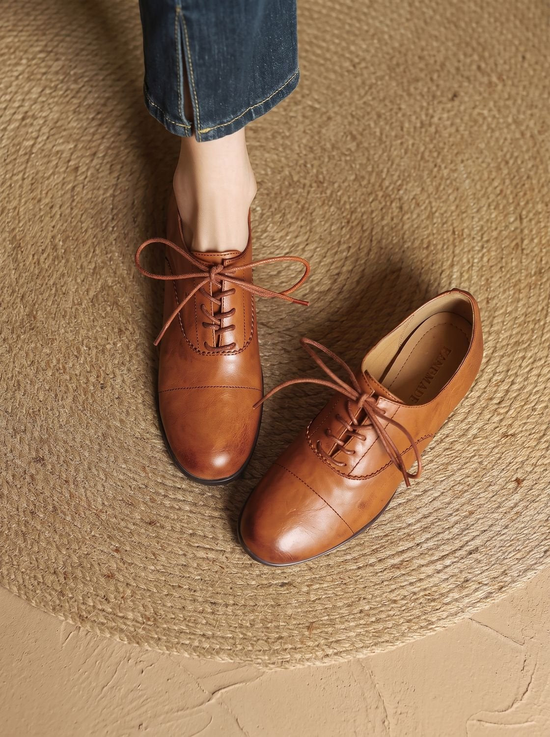 Side view of a women's leather lace-up Oxford flat shoe
