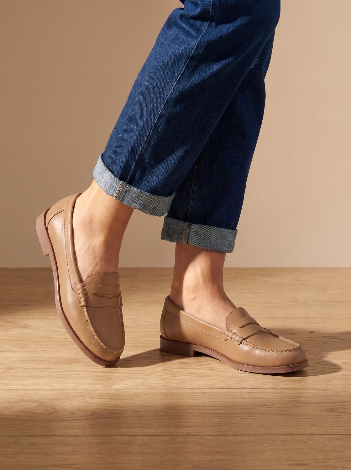 Side view of a women's leather penny loafer with slip-on design
