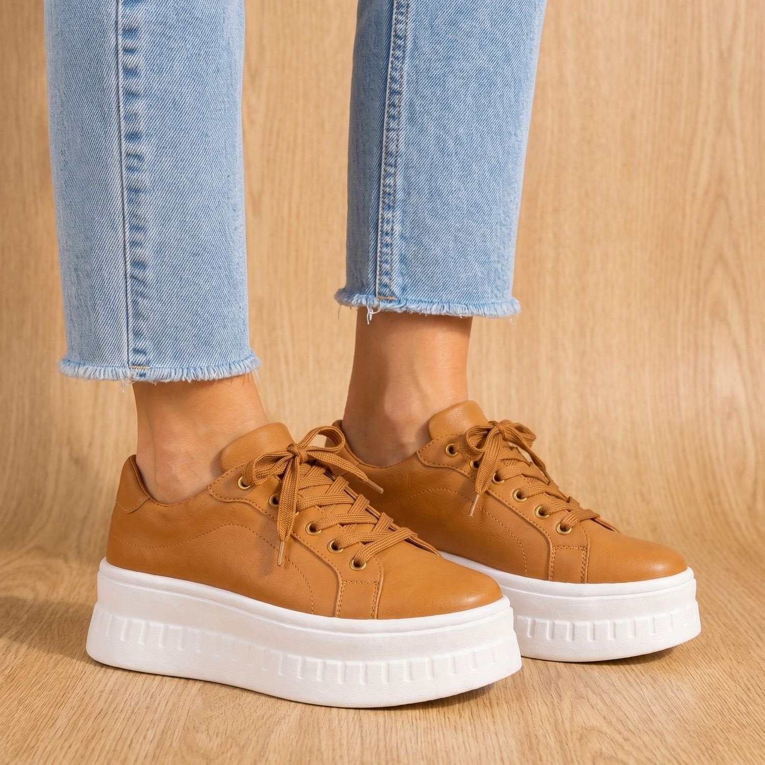Pair of women's tan arch support sneakers shown from the side