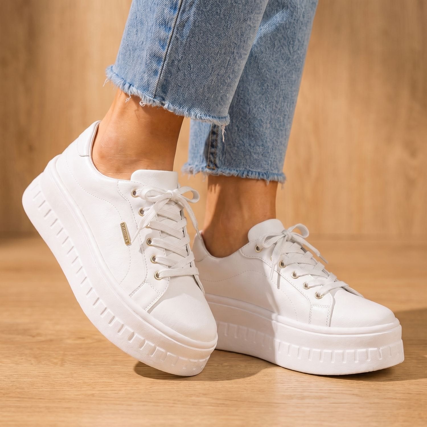 Tan women's sneakers featuring a raised platform sole and lace-up closure