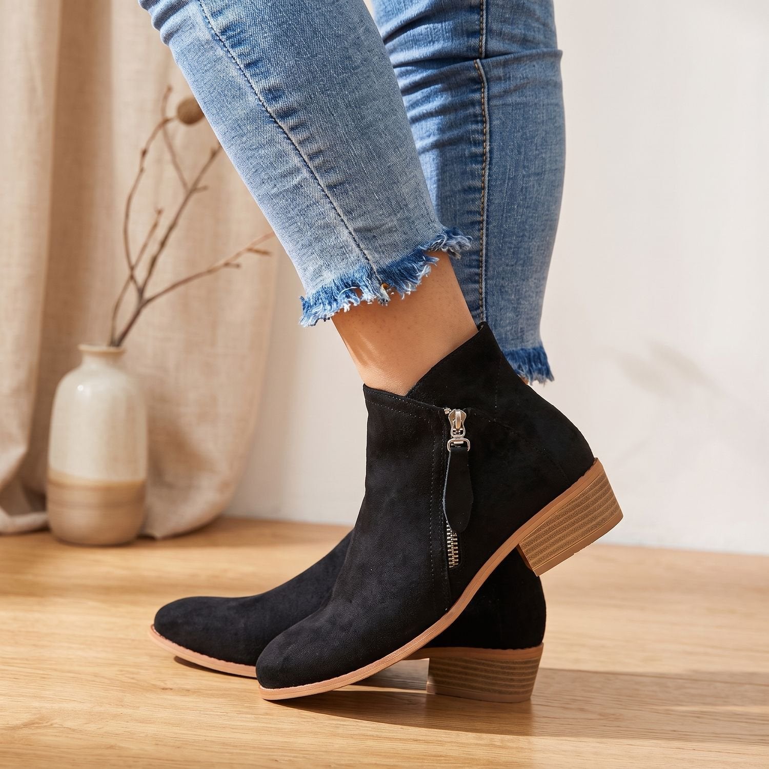 Close-up of the side zipper on a women's suede-look ankle boot